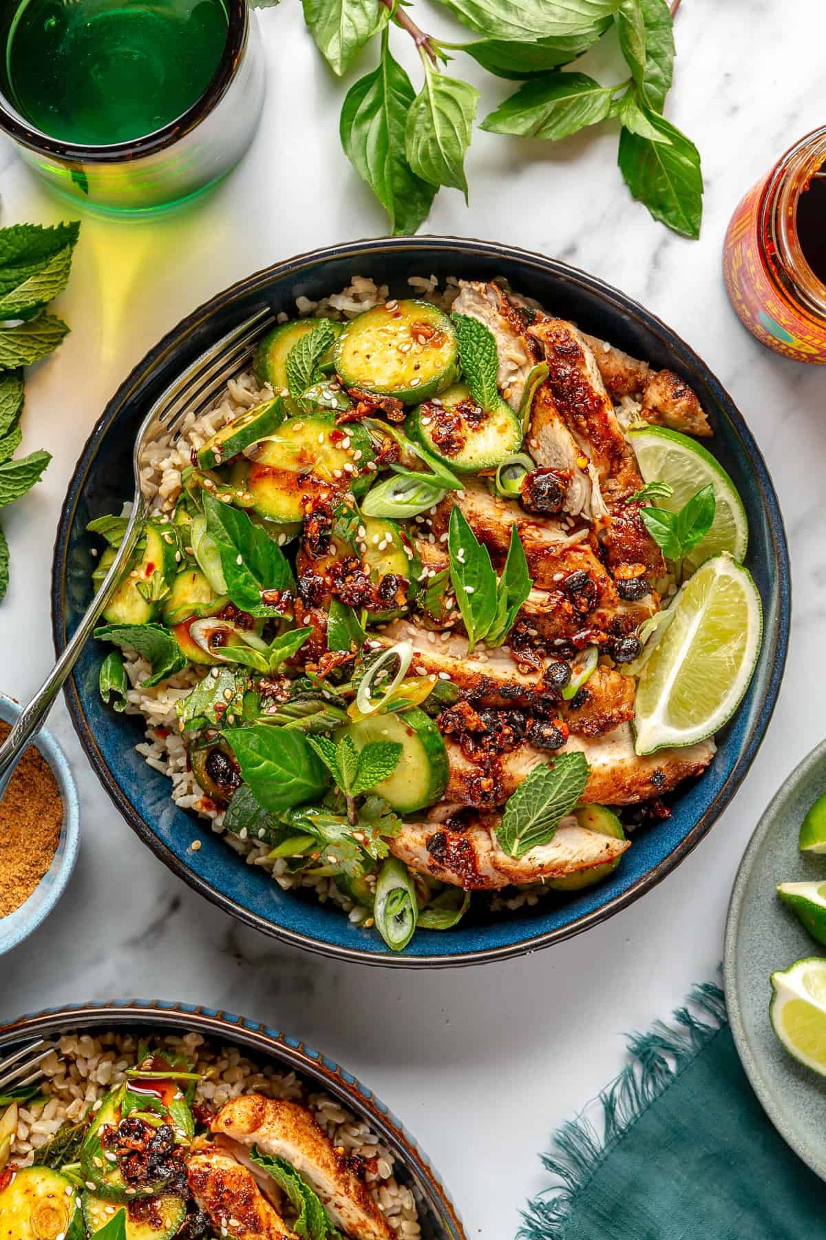 Charred chili chicken bowl with cucumbers, herbs, and lime
