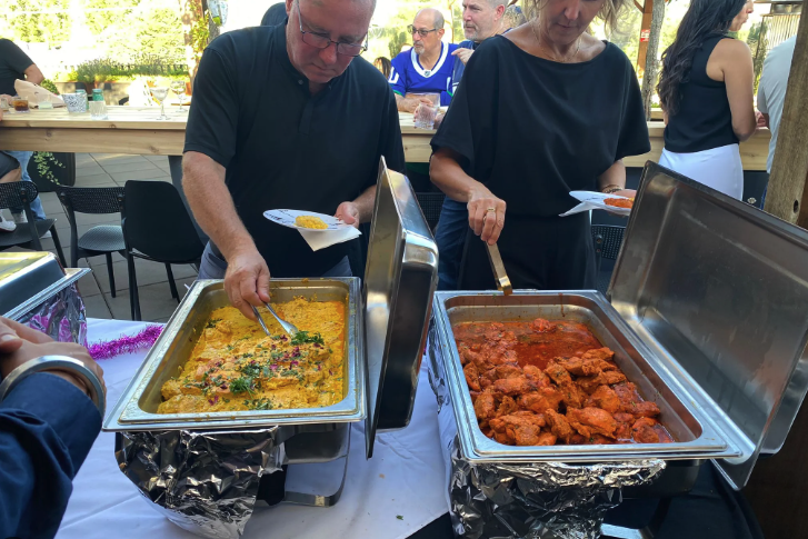 Guests serving themselves from buffet trays at an outdoor catered event