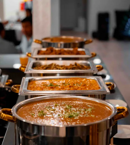 A neat line of covered chafing dishes prepared for buffet-style event service
