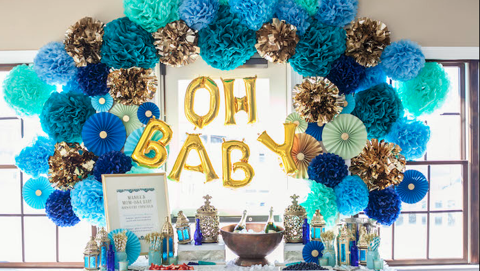 A baby shower dessert and drinks table set beneath a blue balloon backdrop
