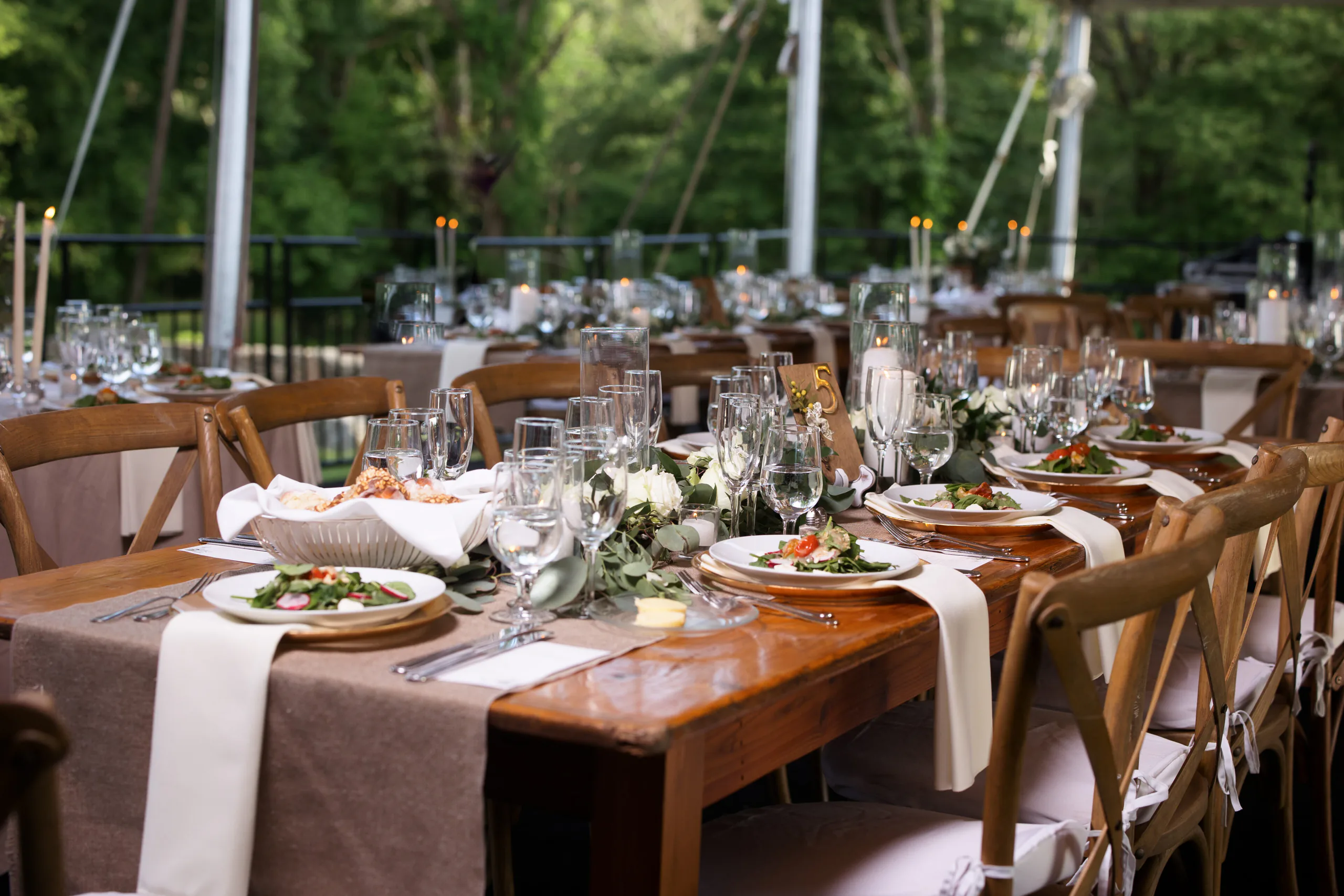 Guests seated under a decorated tent for a catered celebration dinner