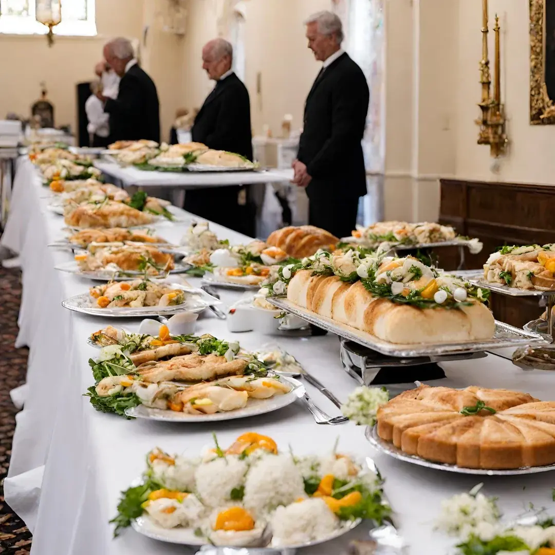 A long repast buffet table arranged with platters, breads, and floral accents before guests are served