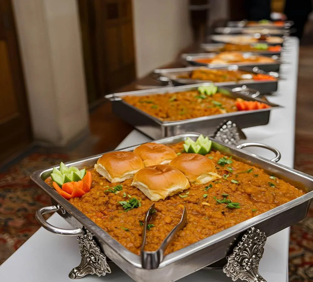 A row of buffet trays and warm dishes arranged for a home celebration