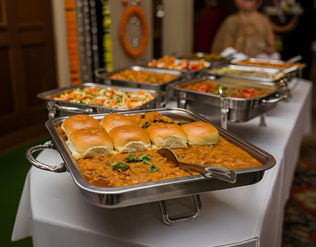 A tray of savoury buns and hot dishes leading a housewarming buffet setup