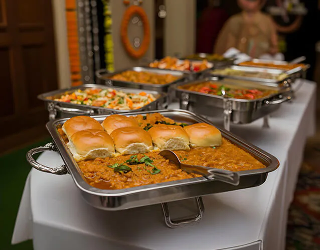 A tray of savoury buns and hot dishes leading a housewarming buffet setup